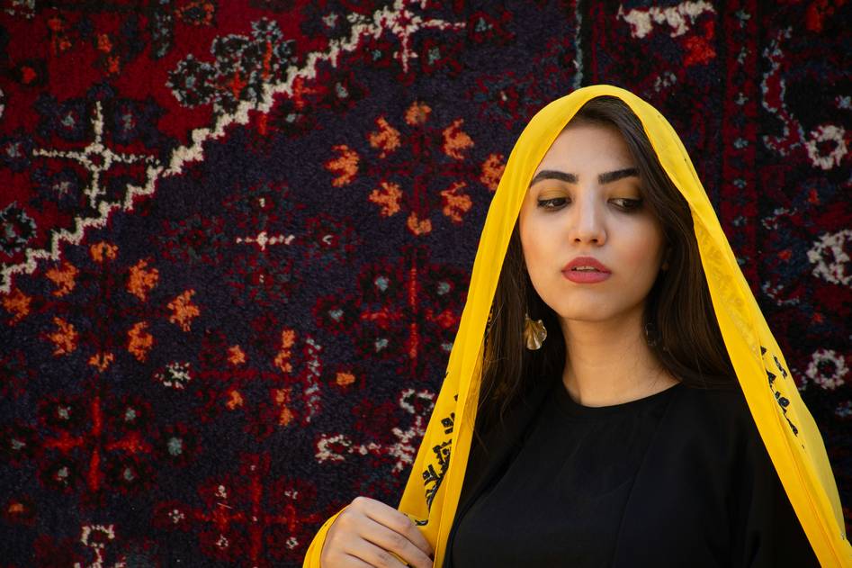 A woman smiling while wrapping her hair in a luxurious hair turban