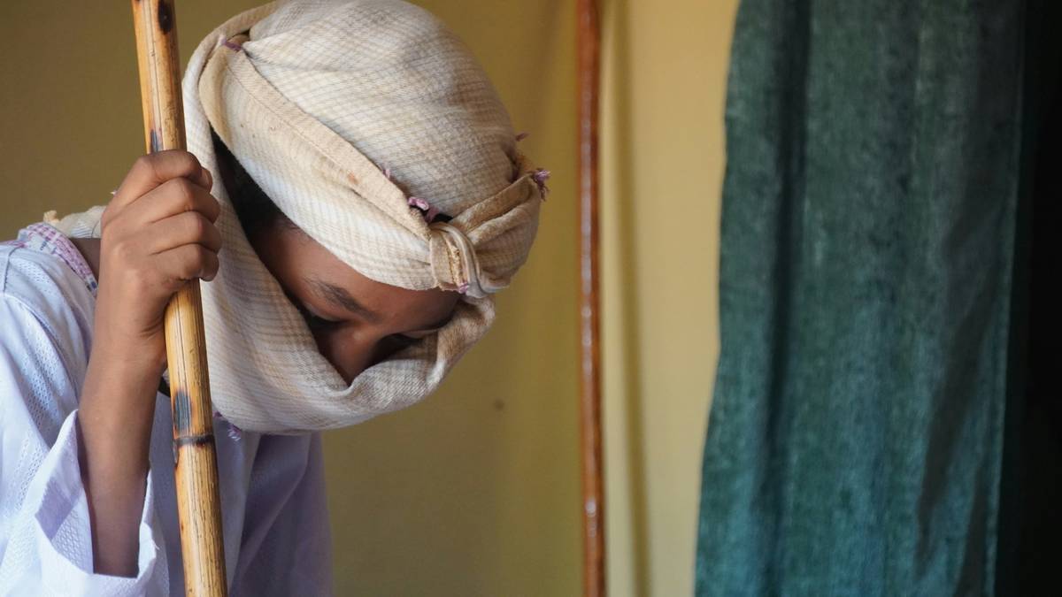 Woman wearing a colorful traditional hair wrap with curly hair styled underneath