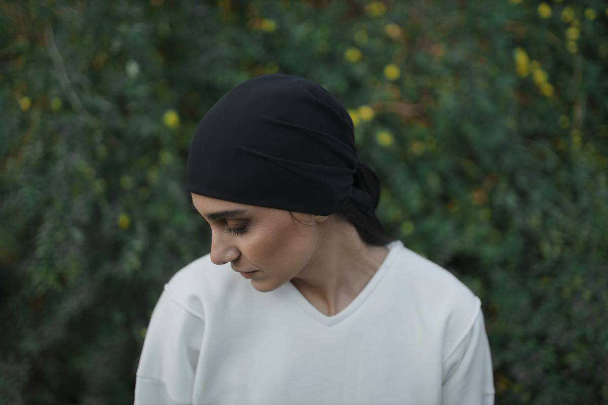 A woman wearing a stretch turban, showcasing its soft texture and snug fit.