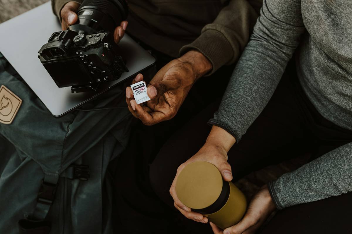 person holding orange and white coffee cup