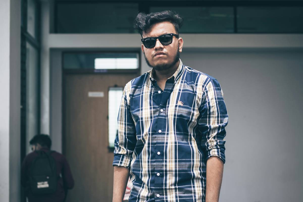 young attractive man posing in a tropical location, with sunglasses.