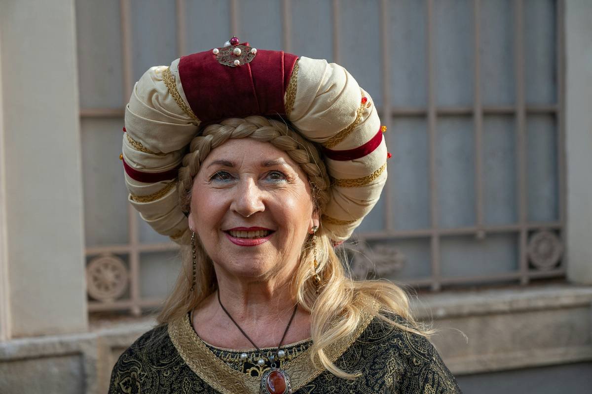 Woman wrapping her hair in a modern headscarf made of satin for overnight protection